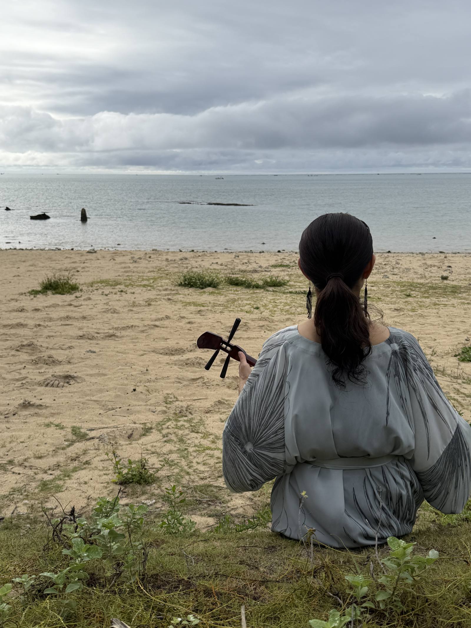 浜辺で三線を奏でる
